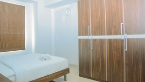 Une chambre à coucher avec un lit, une armoire en bois et une horloge murale.