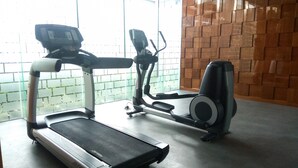 Un gimnasio con una cinta de correr y una máquina elíptica.