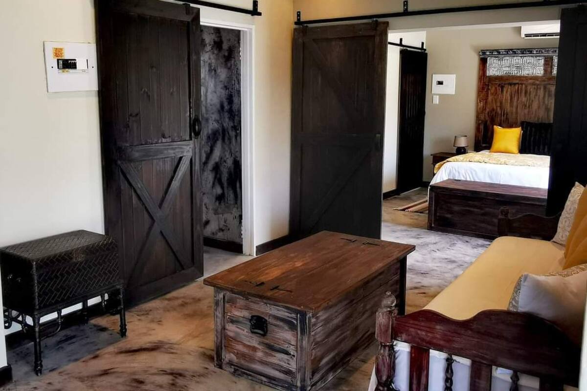 A bedroom with a bed, a wooden chest, a bench, and a sliding door.