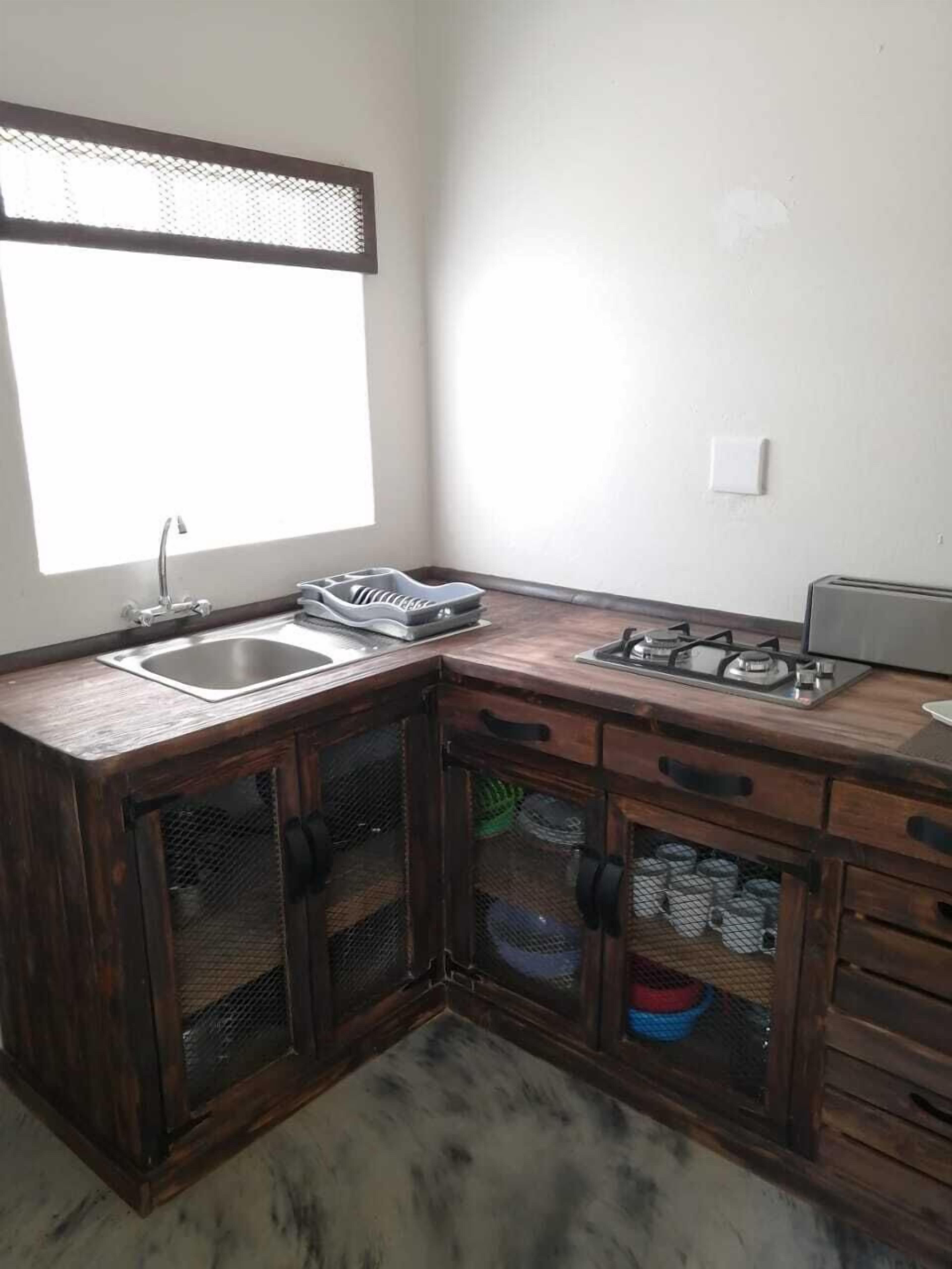 Una cocina con un lavamanos, estufa y armarios.