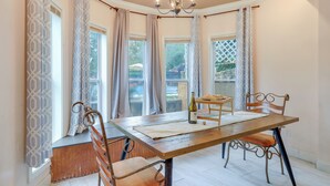 A dining area with a wooden table, metal chairs, and a chandelier.