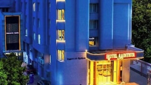 Un moderno edificio de hotel con un cartel llamativo que dice "HOTEL ADITHYA" en la parte superior.