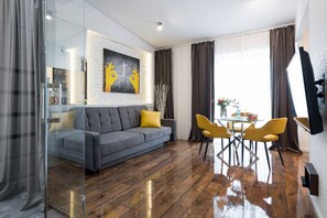 Relax in this stylish living space with a sofa, dining table, and flat-screen TV.