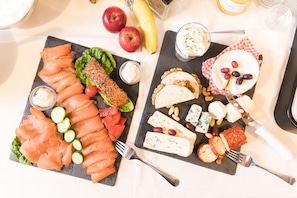 A charcuterie board with various cheeses, fruits, and smoked salmon. - Vitalhotel Garni Vier Jahreszeiten (Bad Fuessing)