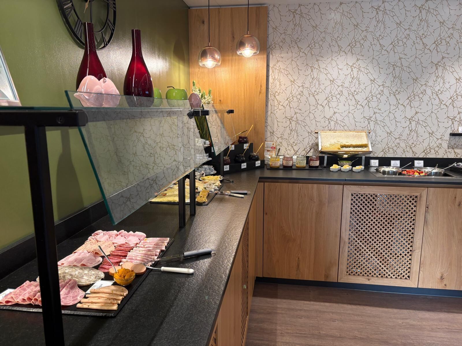 Een buffetruimte met diverse gerechten, een klok en decoratieve vazen.