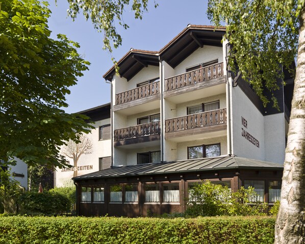 A multi-story hotel with balconies, a covered entrance, and a sign indicating it is a "JAMESZETTEN" hotel. - Vitalhotel Garni Vier Jahreszeiten (Bad Fuessing)