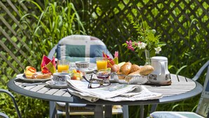 Une table ronde avec des aliments pour le petit-déjeuner, un journal et une paire de lunettes.