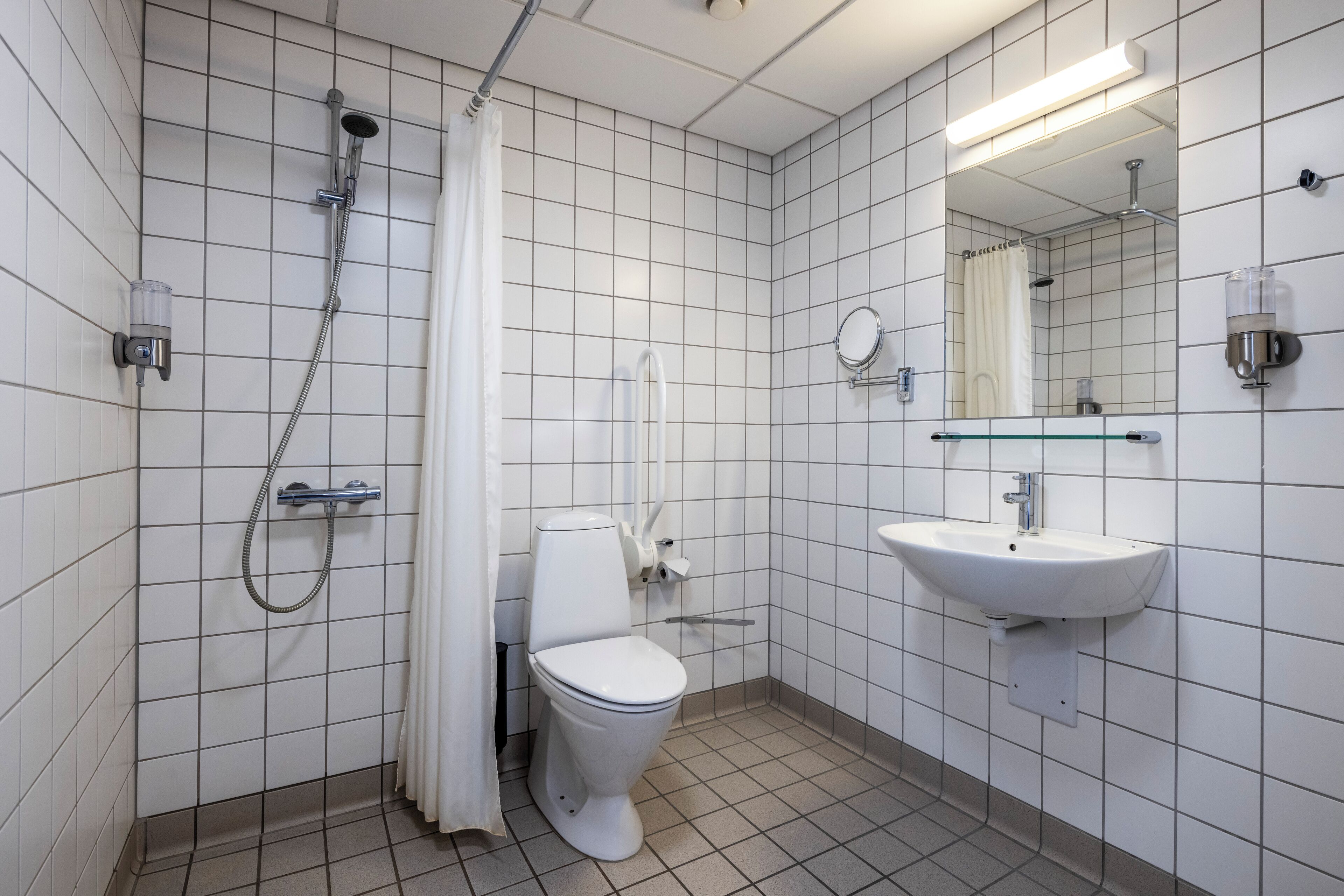 Une salle de bain moderne équipée de toilettes, d’une douche et d’un lavabo.