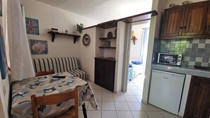 Estudio básico, 1 cama de matrimonio, patio | Cocina privada | Frigorífico, placa de cocina, utensilios de cocina y mesa de comedor