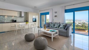 Eine moderne Wohnung mit Küche, Essbereich und Wohnzimmer mit großem Fenster.