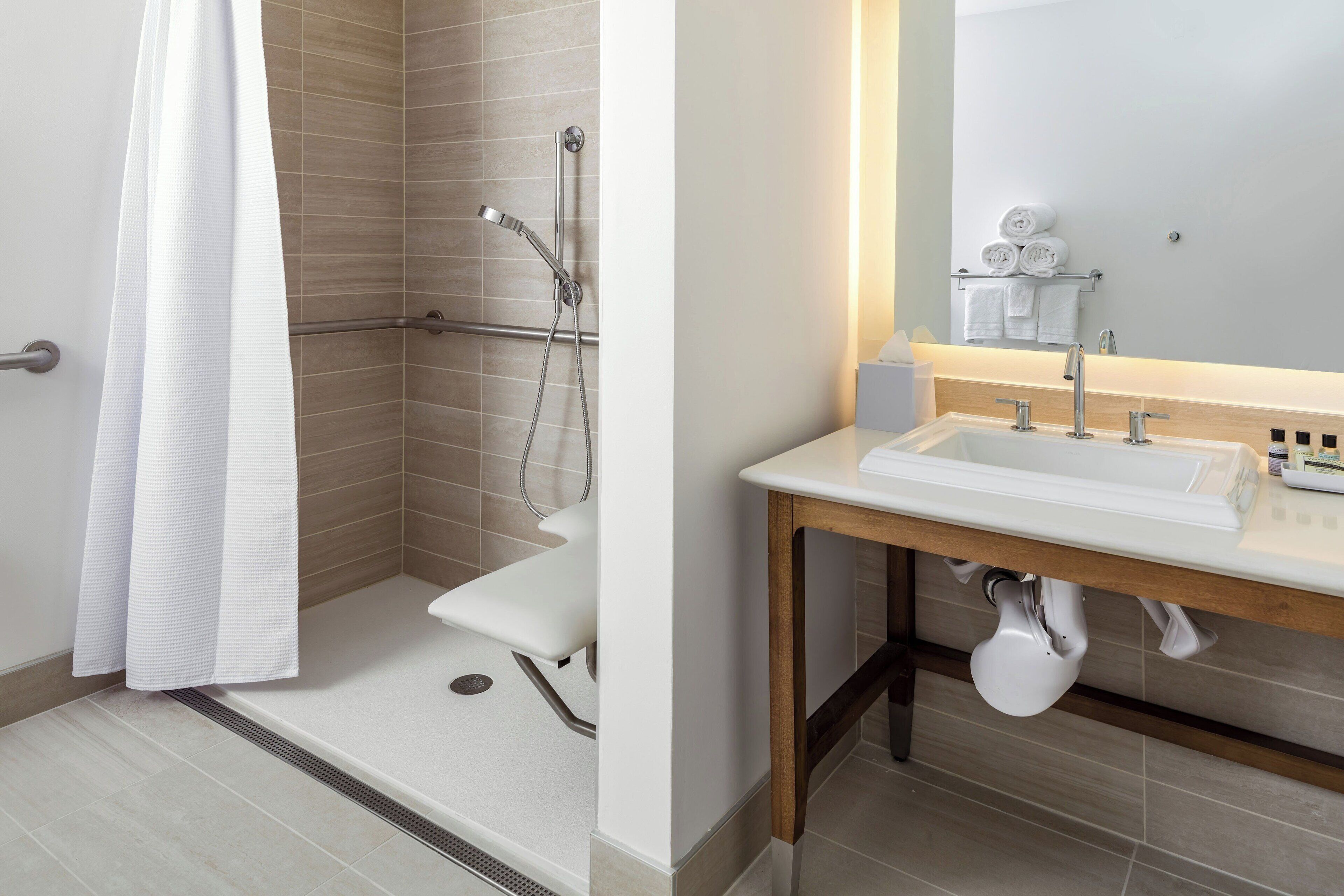 A modern bathroom with a shower, toilet, and sink.
