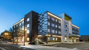 Et moderne hotel med murstensfacade, flere etager og en velbelyst indgang.