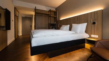 Un dormitorio moderno con cama suspendida, suelo de madera y estanterías empotradas.