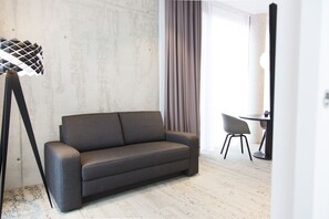 Business Double Room, 1 King Bed with Sofa bed | Living area | 42-inch flat-screen TV with satellite channels, TV, heated floors - Toploft The Aparthotel (Crailsheim)