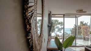 Un interior moderno con un ventanal grande, un tapiz tejido y una planta verde.