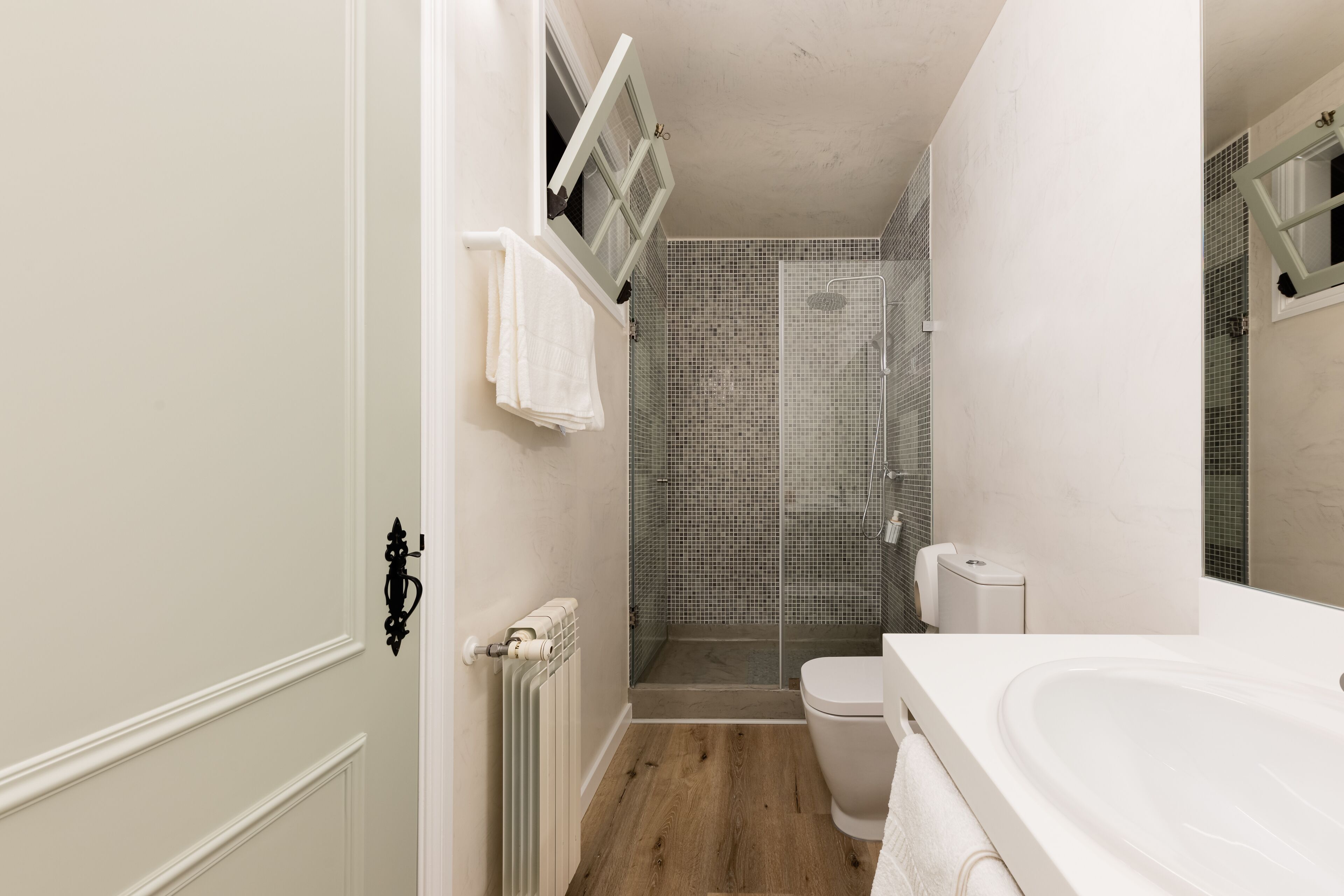 A bathroom with a shower, toilet, and sink.