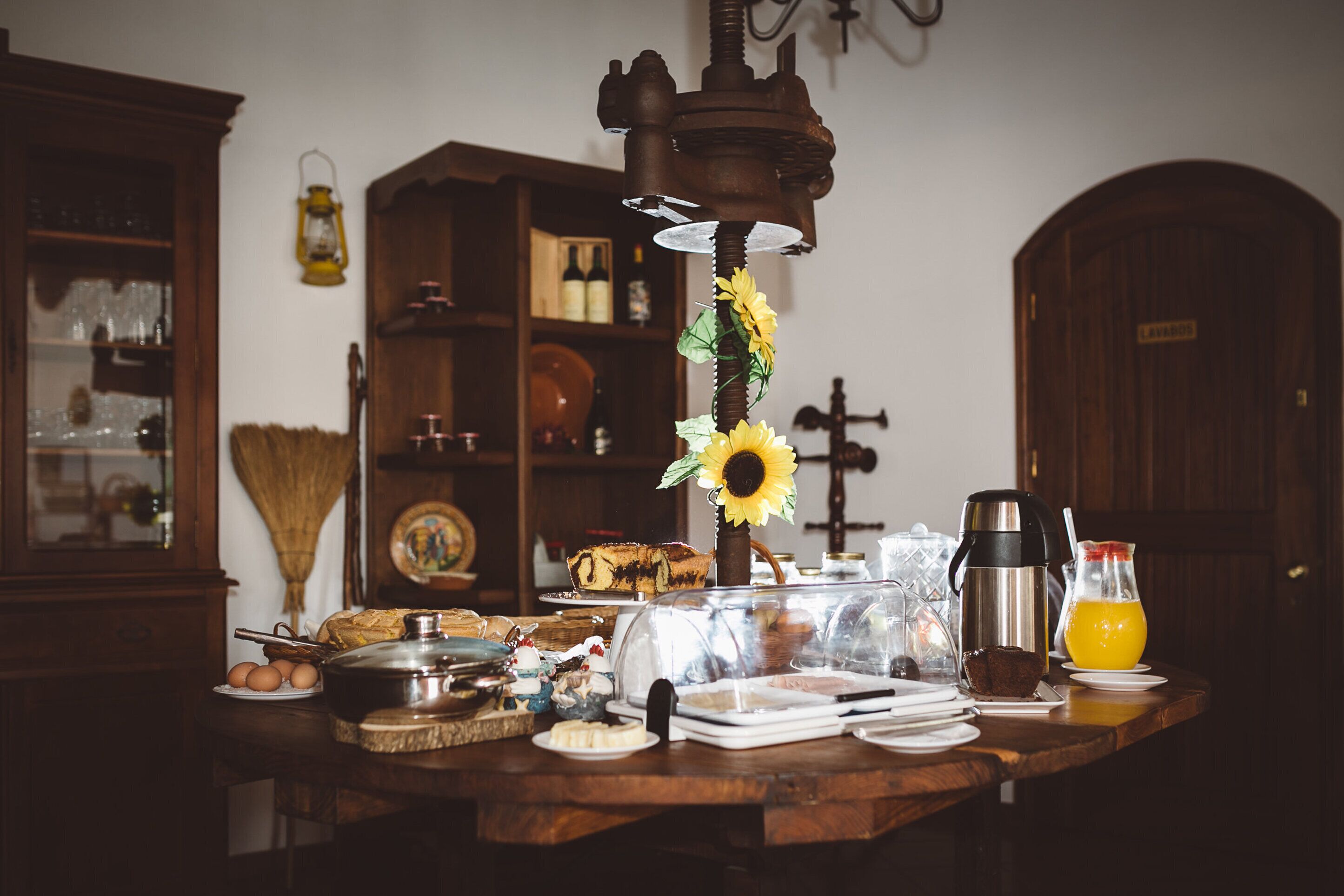 A breakfast table with various food items and a coffee maker.