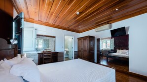 Un dormitorio con una cama grande, techo de madera y televisor instalado en la pared.