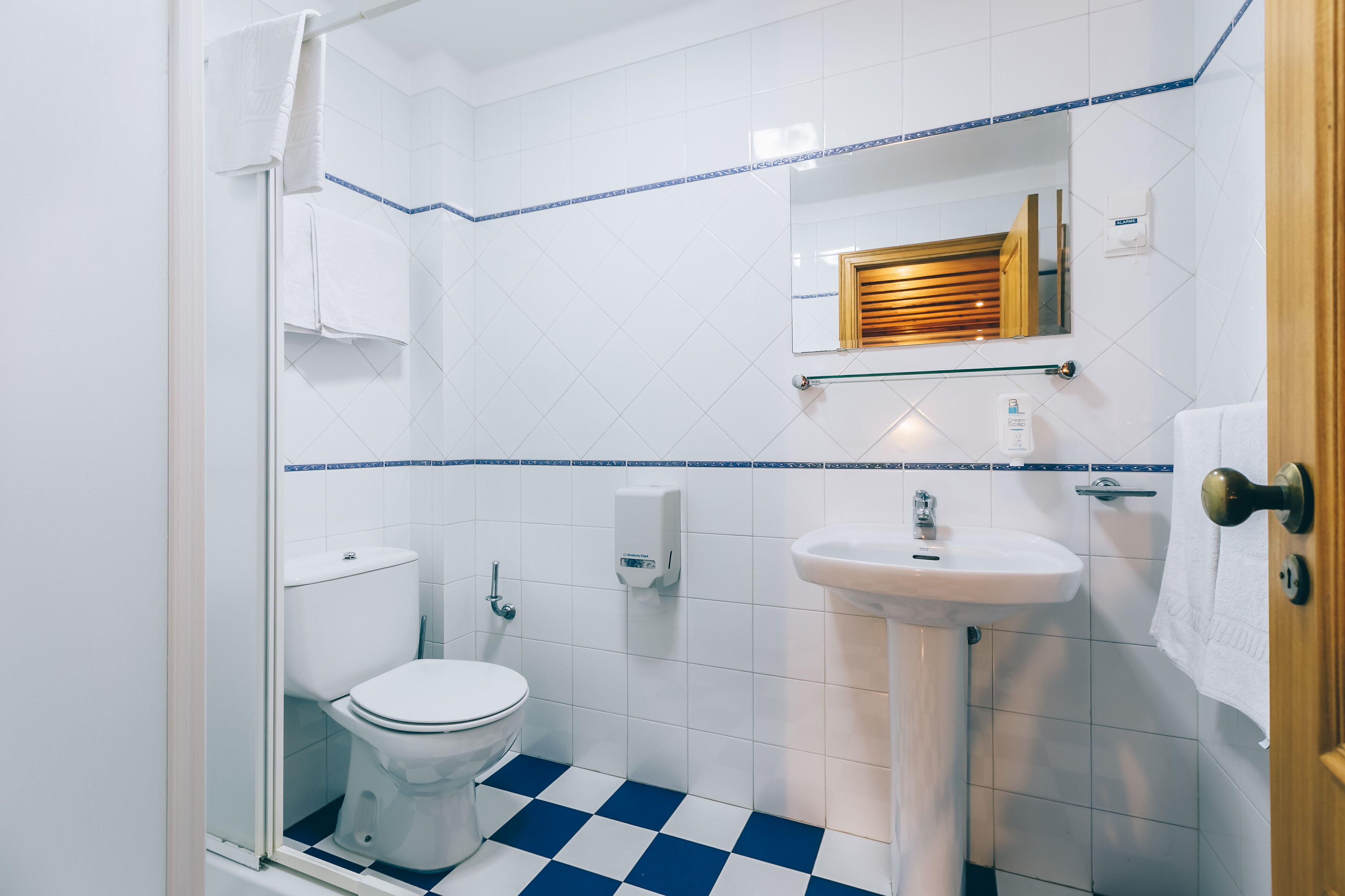 A bathroom with a toilet, sink, and shower area.