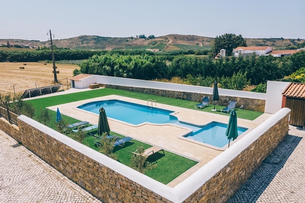 Una piscina al aire libre de temporada, sillones reclinables de piscina