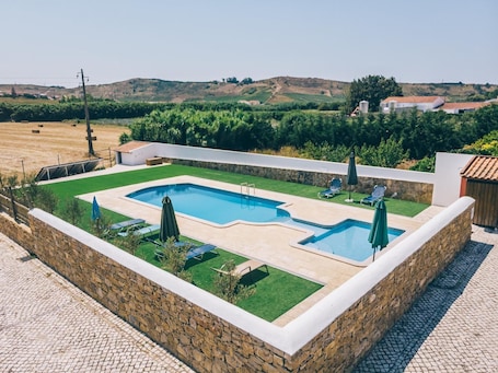 Una piscina al aire libre de temporada, sillones reclinables de piscina