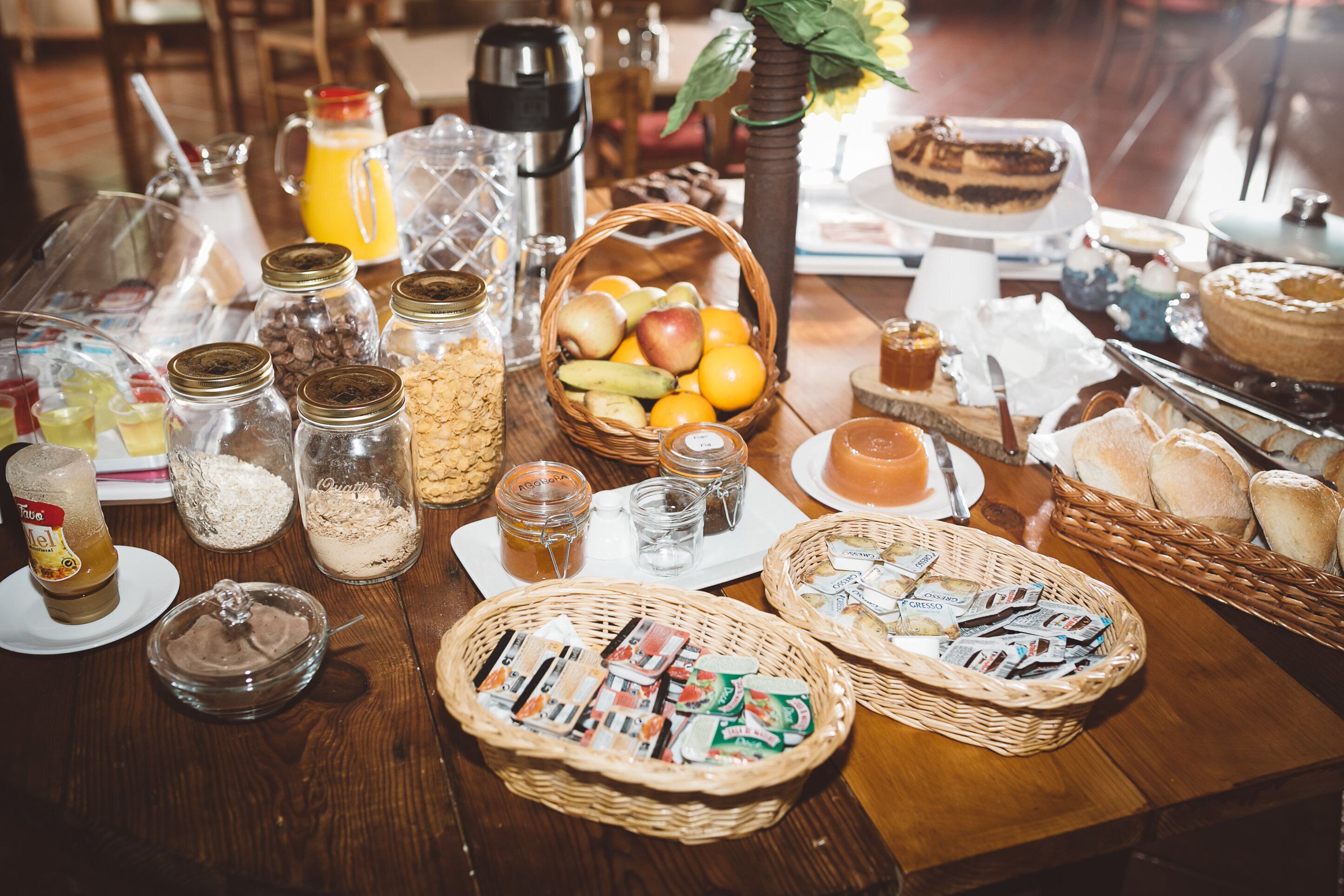 Un bufé de desayuno con diversos alimentos, bebidas y acompañamientos.