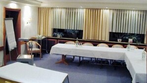 A conference room with a long table, chairs, a projector, and a TV screen. - Hotel Adler (Lichtenstein)