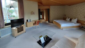 A bedroom with a bed, a desk, a TV, and a sofa. - Hotel Adler (Lichtenstein)
