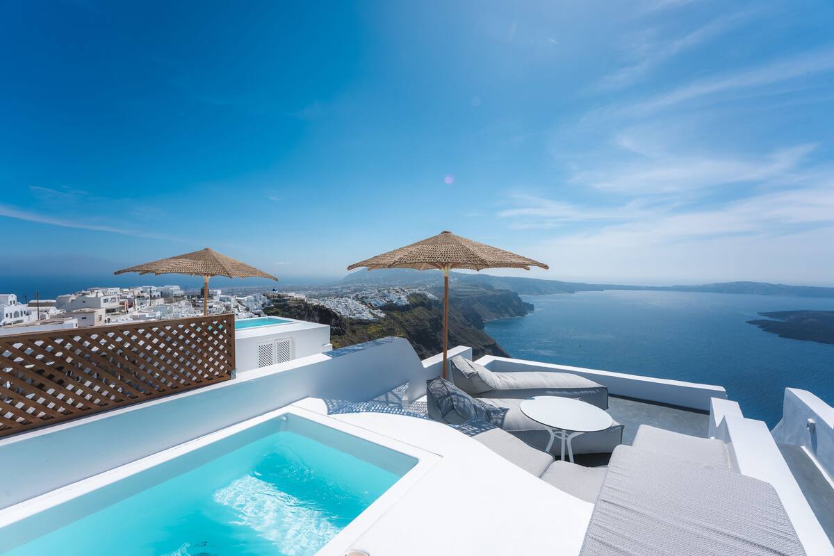 Un espace piscine aménagé sur le toit, offrant une vue dégagée sur la mer et une portion de la côte au loin.