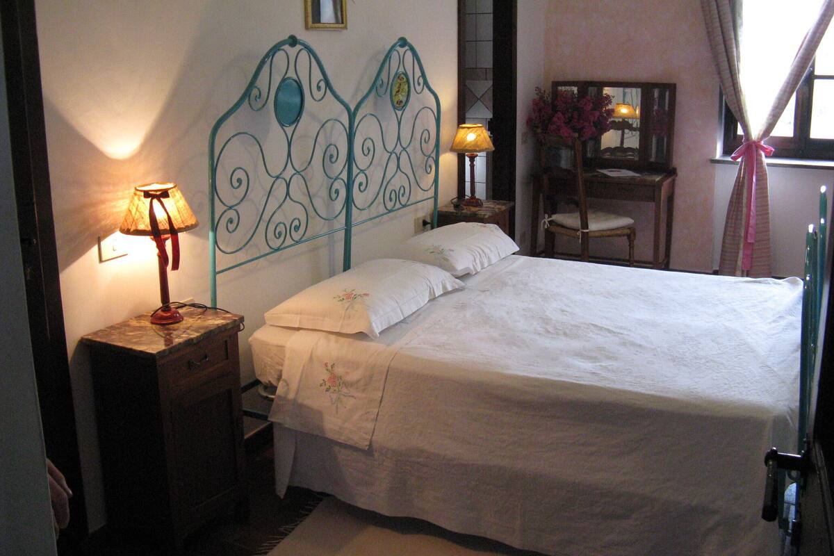 Une chambre à coucher avec un lit, des lampes de chevet, un miroir et une chaise.