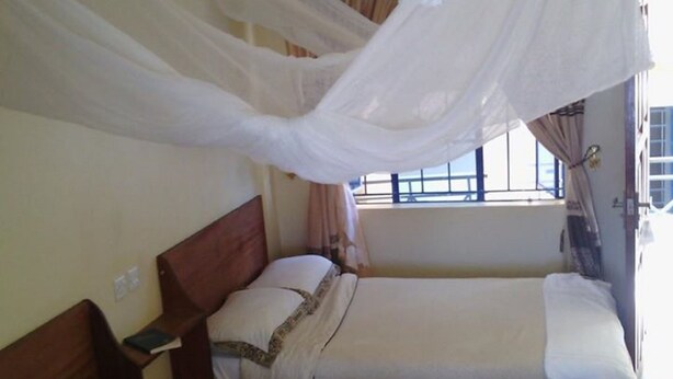 A room with two beds, one with a canopy.