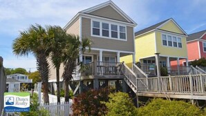 A two-story house with a balcony and a staircase leading to the upper floor.