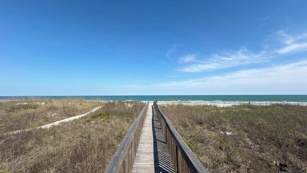 A wooden boardwalk leading to a beach with dunes and ocean in the background. - Inlet Pointe 37 - Second Row (Channelfront) in Garden City Beach (Garden City)
