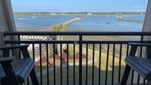 A balcony with a view of a water body, a dock, and a distant shoreline. - Inlet Pointe 37 - Second Row (Channelfront) in Garden City Beach (Garden City)