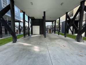 Walkway leads to a building with a white door and staircase.