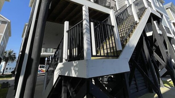 A multi-story residential building with a balcony on the second floor and a staircase leading to the upper levels. - Just Beachin' - Second Row complex in Garden City Beach (Garden City)