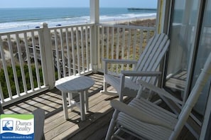 Enjoy ocean views from this deck with a chair and table.