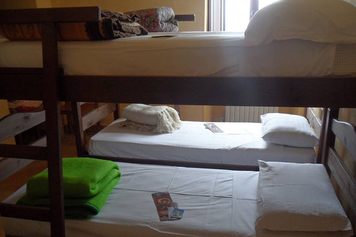 Une chambre avec un lit superposé, comportant deux lits, chacun avec une literie et des oreillers blancs.