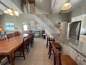 Enjoy meals and social gatherings around the large dining table, surrounded by comfortable seating and beautiful artwork.