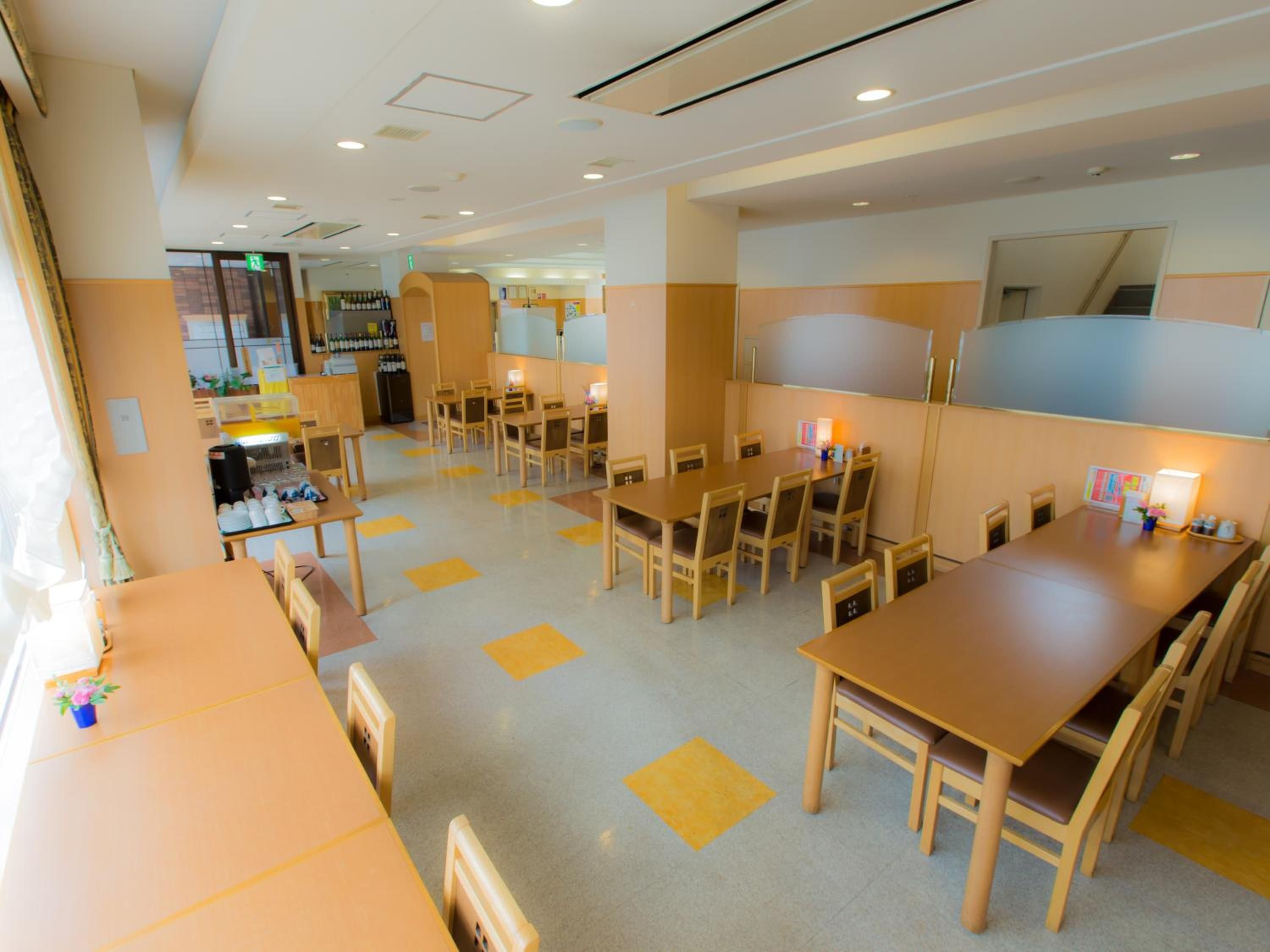A hotel lobby with multiple seating areas, a reception desk, and a visible bar area.