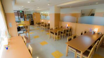 A hotel lobby with multiple seating areas, a reception desk, and a visible bar area.