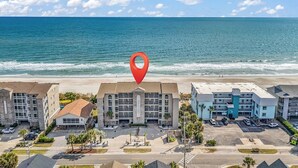 A beachfront hotel with multiple buildings, a parking lot, and a view of the ocean. - Surfwatch II 202 - Oceanfront in Surfside Beach (Surfside Beach)