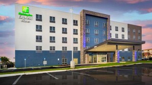 Un edificio de Holiday Inn Express con diseño moderno, que presenta una fachada plana y una zona de entrada cubierta.