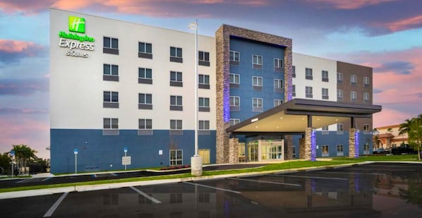 A Holiday Inn Express building with a modern design, featuring a flat facade and a covered entrance area. - Holiday Inn Express & Suites Fort Myers Airport by IHG (Fort Myers)