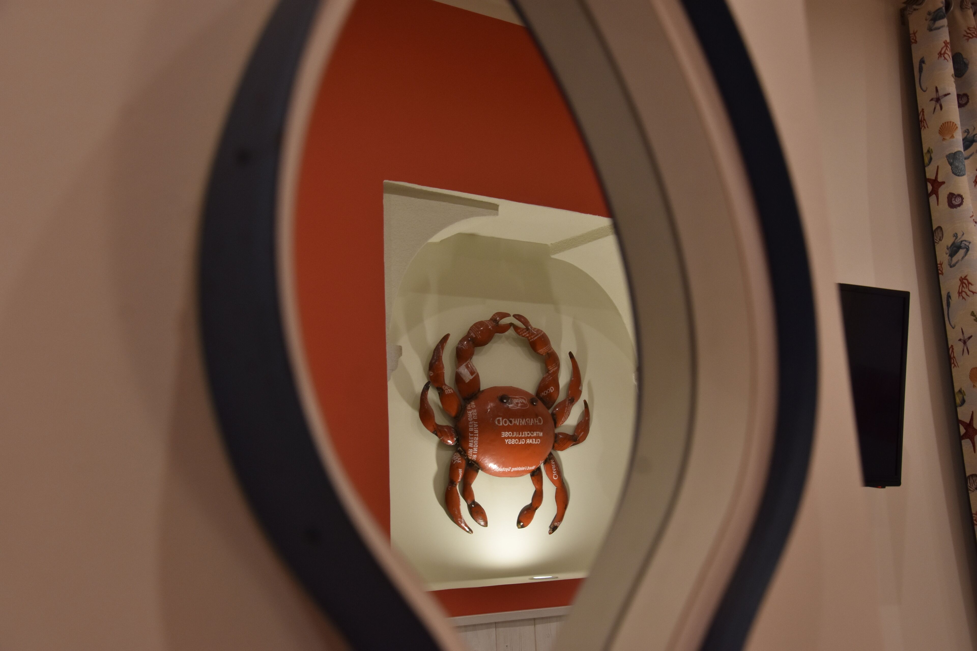 Ett runt fönster med en krabbdekor på insidan.