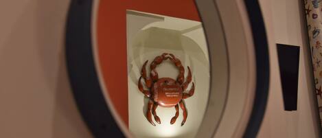 Une fenêtre ronde ornée d’un motif représentant un crabe à l’intérieur.