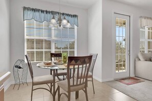 A dining area with a round table, chairs, and a chandelier. - South Fort Myers Gated Community! Heated Pool & Hot Tub! Close to Beaches, Shopping & Dining! (Fort Myers)