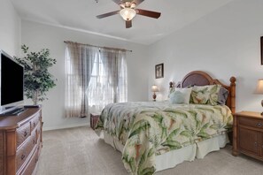 A bedroom with a bed, a television on a dresser, a ceiling fan, and a window with curtains. - South Fort Myers Gated Community! Heated Pool & Hot Tub! Close to Beaches, Shopping & Dining! (Fort Myers)