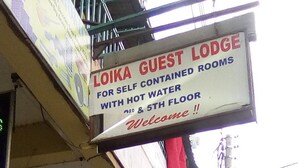 A sign for Loika Guest Lodge advertising self-contained rooms with hot water on the 4th and 5th floors. - Loika Guest Lodge - Nakuru (Nakuru)