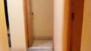 A narrow hallway with tiled flooring and wooden doors on either side. - Loika Guest Lodge - Nakuru (Nakuru)